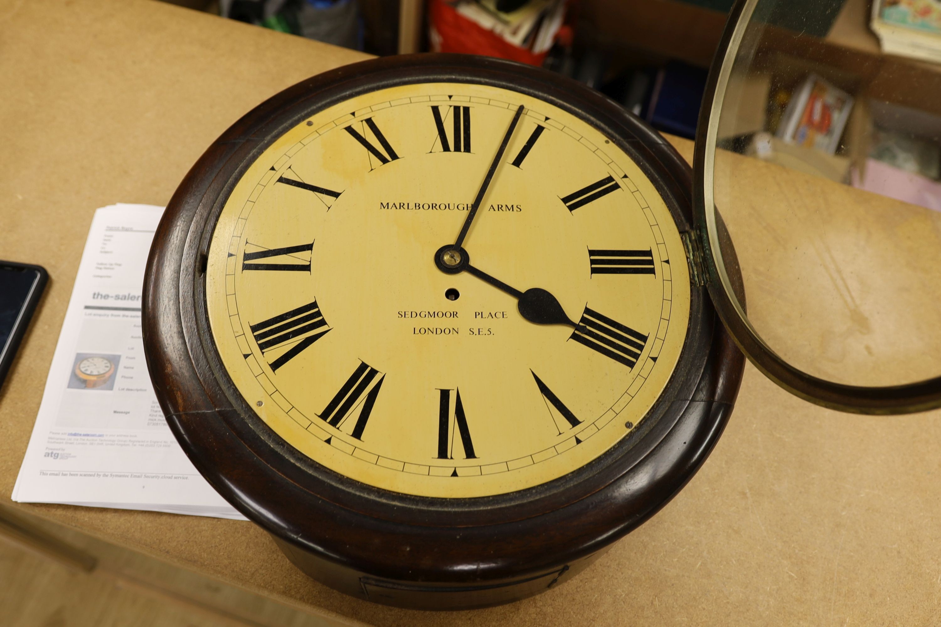 A mahogany dial clock, Marlborough Arms, Sedgmoor Place, London SE5., 48 cms diameter.